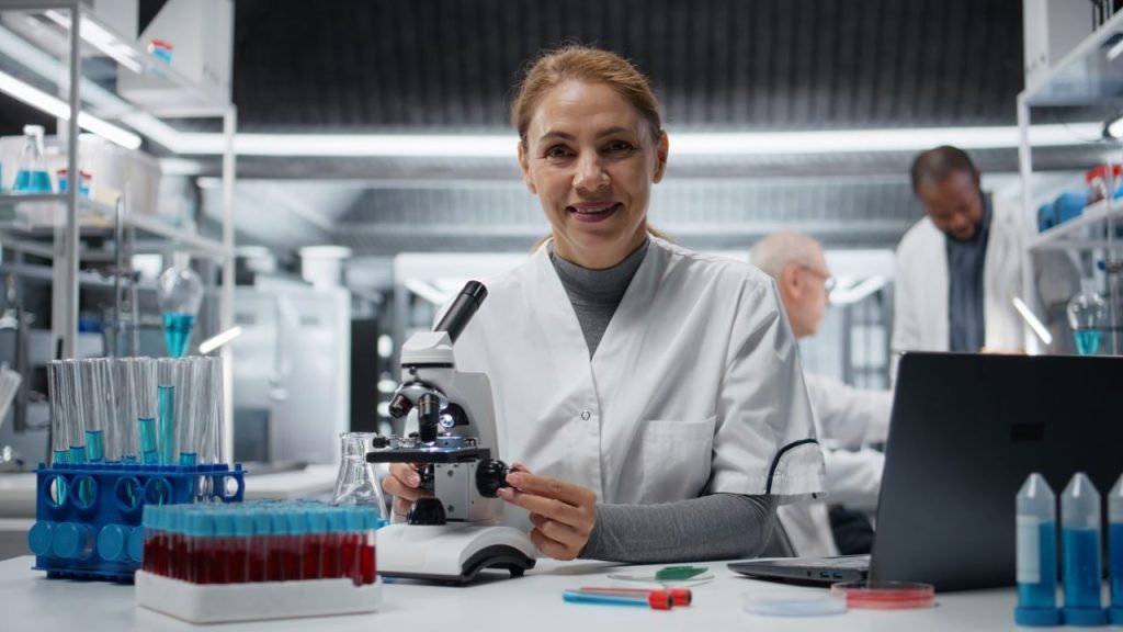 Scientifique travaillant sur une paillasse de laboratoire équipée de verrerie et d’instruments.