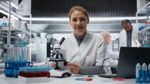Scientifique travaillant sur une paillasse de laboratoire équipée de verrerie et d’instruments.