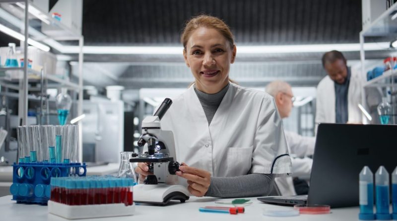 Scientifique travaillant sur une paillasse de laboratoire équipée de verrerie et d’instruments.